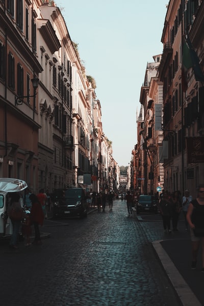 During the day, people walking in the streets of between buildings
